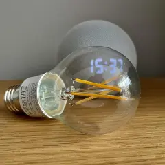 Bombilla inteligente con reloj digital y un dispositivo Echo Dot. Aprende como hacer que Alexa encienda la luz.