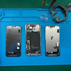 Tres iPhones desarmados en una alfombrilla azul. El led integrado se puede cambiar, facilitando la reparación.
