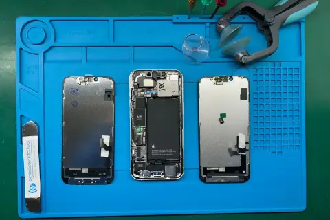 Tres iPhones desarmados en una alfombrilla azul. El led integrado se puede cambiar, facilitando la reparación.